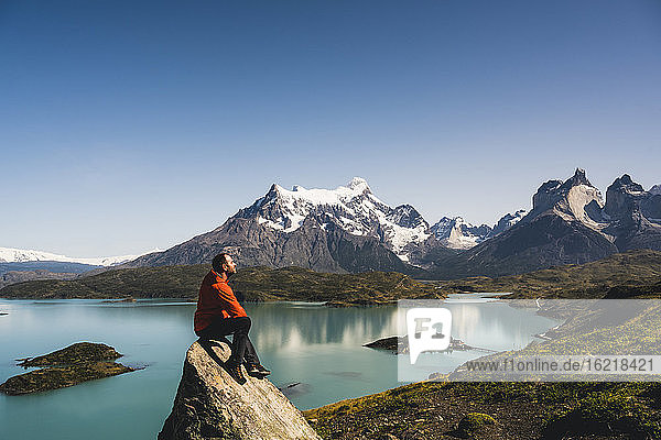 Man sitting on rock at Lake Pehoe in Torres Del Paine National Park  Chile Patagonia  South America