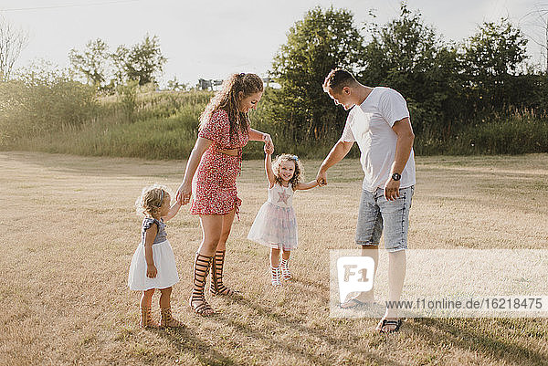 Parents with two daughters standing on a meadow