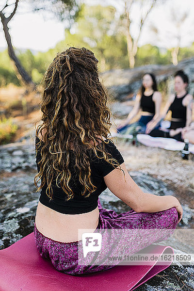 Yogalehrer übt Konzentration mit Frauen im Wald