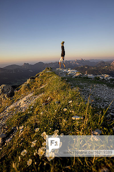 Man doing handstand on viewpoint  Gaishorn  Tyrol  Austria