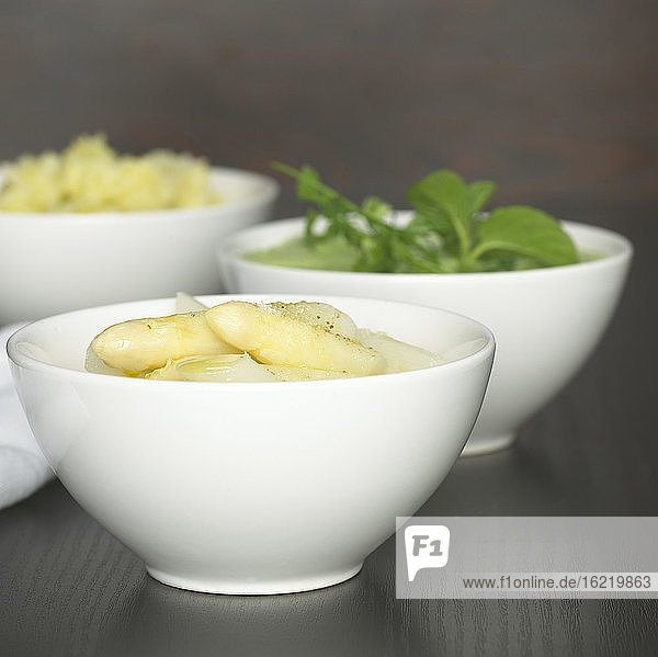 Spargel  Kartoffelpüree und Salat in weißen Schalen  Nahaufnahme
