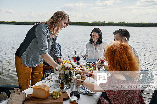 Freunde beim Abendessen an einem See