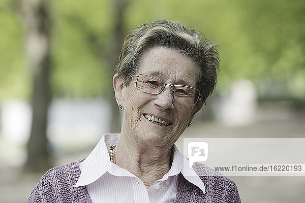 Germany  Cologne  Portrait of senior woman in park  smiling