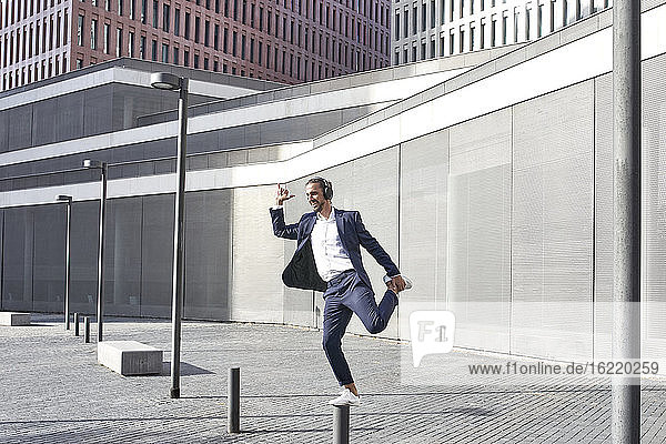 Entrepreneur enjoying music while dancing in city