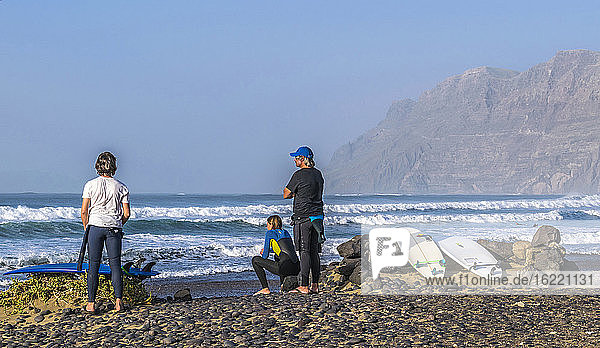 Spanien  Kanarische Inseln  Insel Lanzarote  Surfer beobachten die Wellen