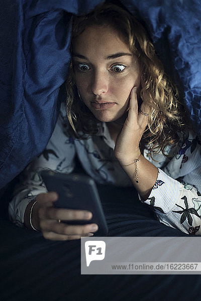 Teenage girl and everyday life. In bed with smartphone