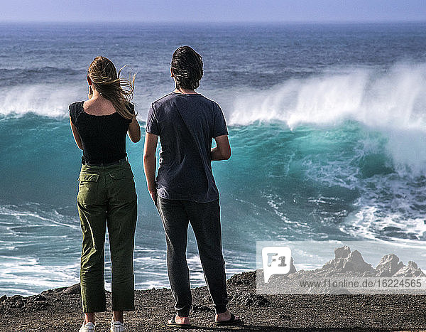 Spanien  Kanarische Inseln  Insel Lanzarote  El Golfo  Teenager fasziniert von den Wellen