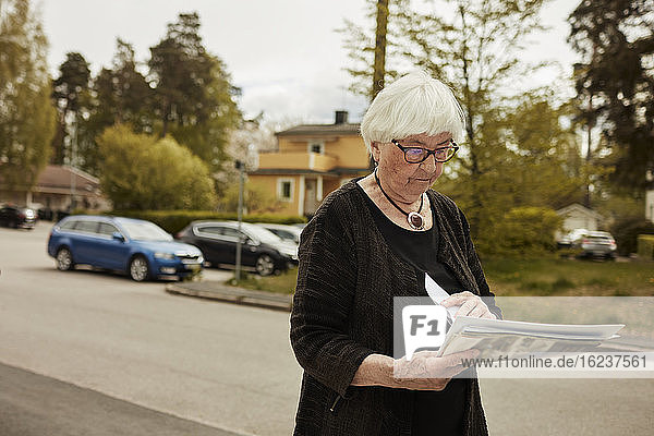 Ältere Frau mit Zeitung in der Hand