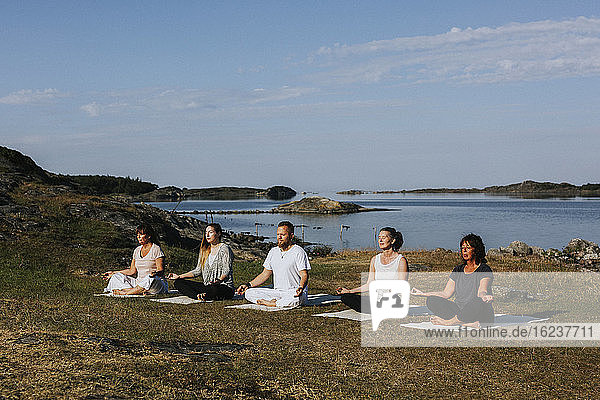 Menschen meditieren auf See