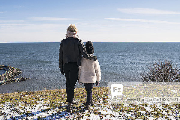 Mutter und Tochter blicken auf das Meer