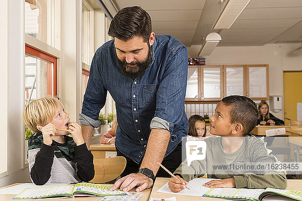 Lehrerin mit Jungen im Klassenzimmer