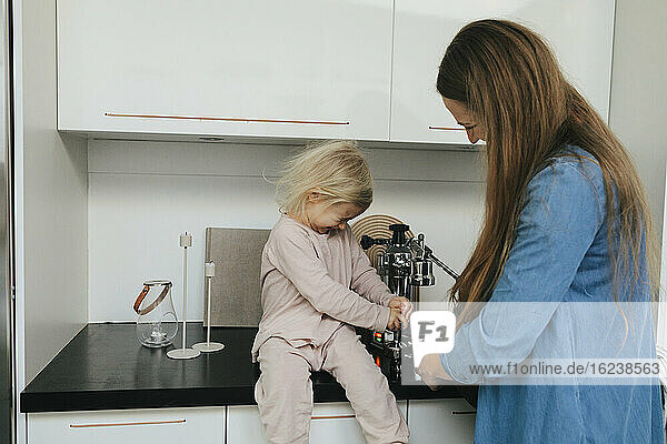 Mother with daughter making coffee