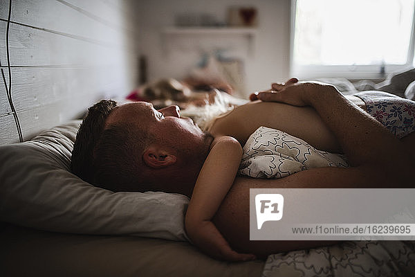 Father and child sleeping in bed