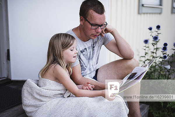 Vater mit lesender Tochter