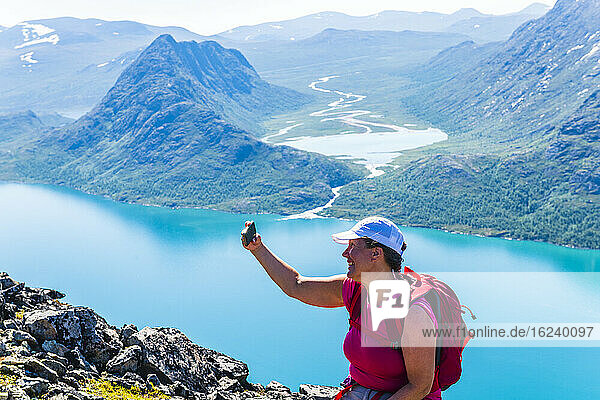 Frau nimmt Selfie in den Bergen
