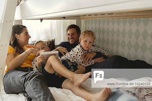 Parents with sons on bed