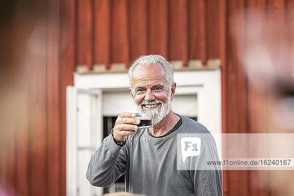 Smiling man having red wine