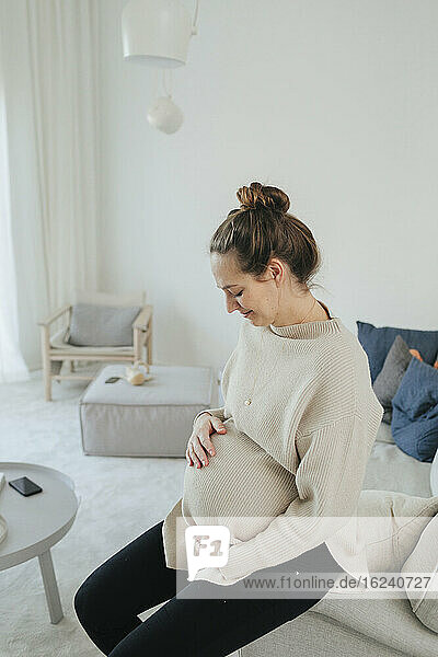 Schwangere Frau entspannt sich im Wohnzimmer