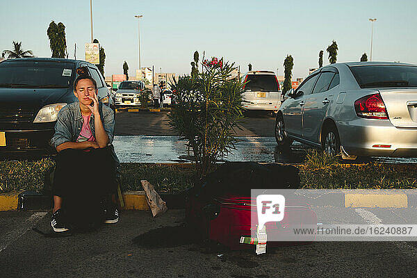 Frau mit Koffern auf Parkplatz