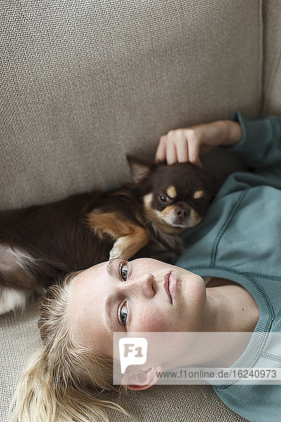 Teenager-Mädchen auf dem Bett liegend mit Hund