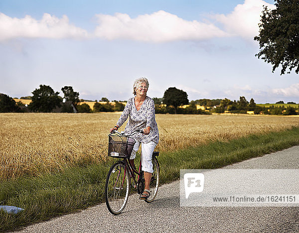 Woman cycling on rural road