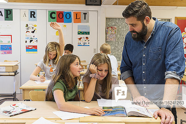 Teacher helping girls in classroom