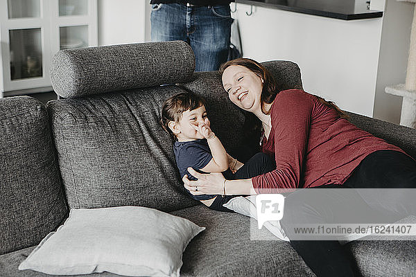 Mother sitting with daughter on sofa