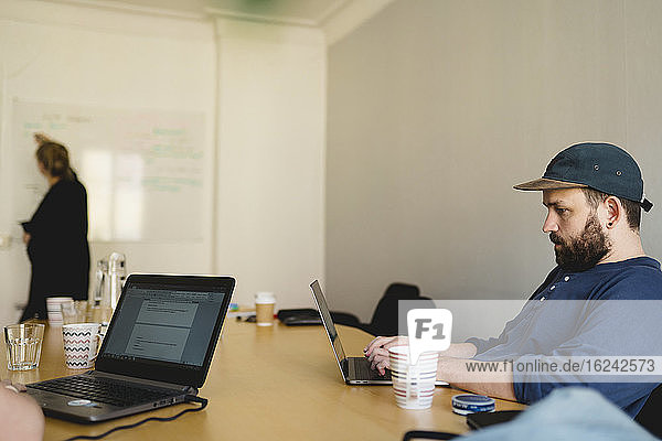 Man using laptop in meeting room