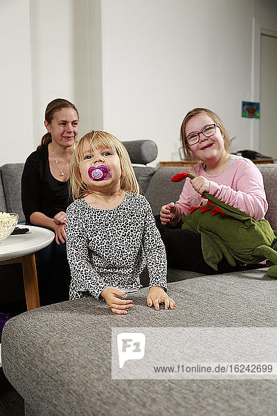 Mother with daughters on sofa