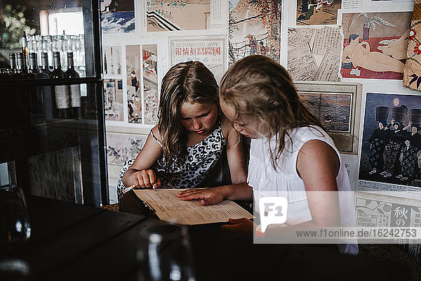 Girls reading menu in cafe