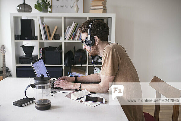 Mann arbeitet am Laptop im Heimbüro