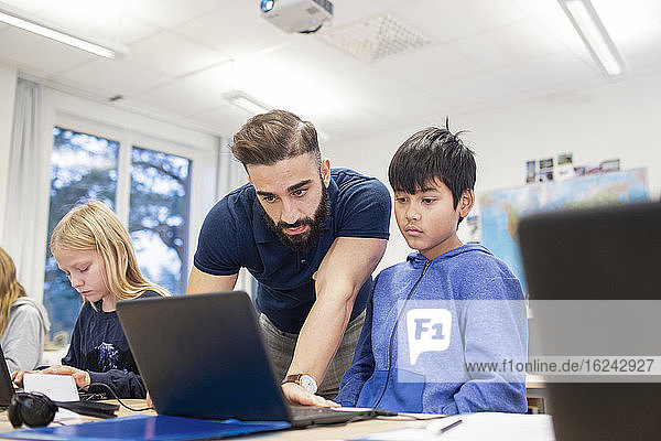 Lehrer hilft Schüler im Klassenzimmer