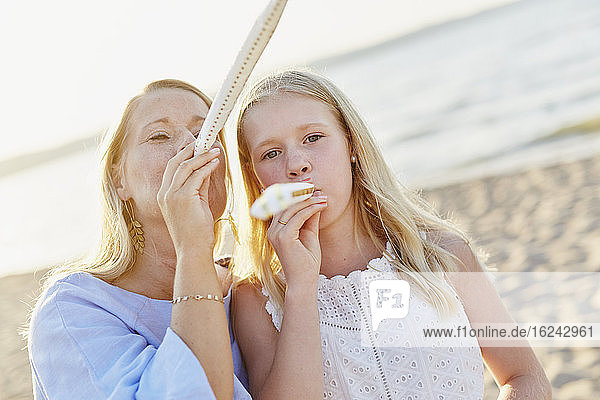 Mother and daughter blowing party horn blowers