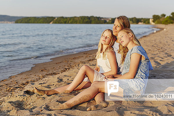 Mutter mit Töchtern am Strand