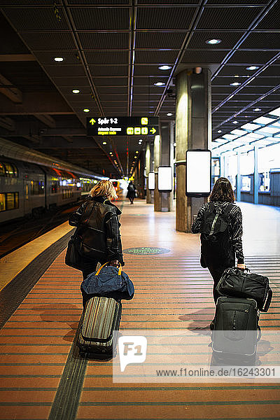 Frauen mit Koffern am Bahnhof
