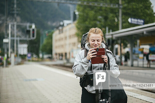 Frau benutzt Mobiltelefon auf dem Bahnhof