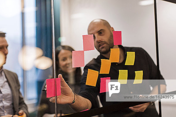 People using adhesive notes at business meeting