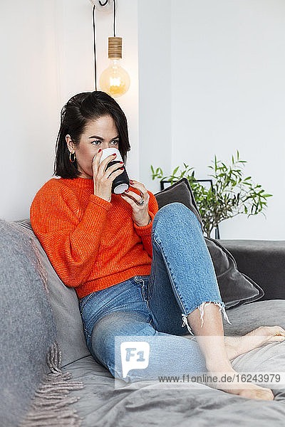Frau mit Kaffee auf dem Sofa
