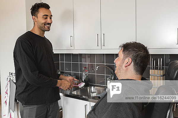 Lächelnde Männer unterhalten sich in der Küche