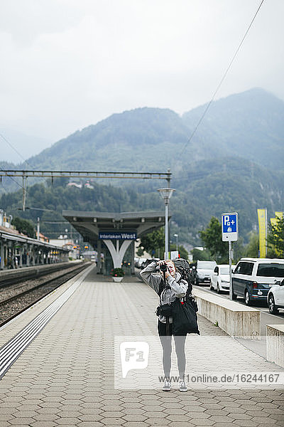 Frau fotografiert auf dem Bahnhof