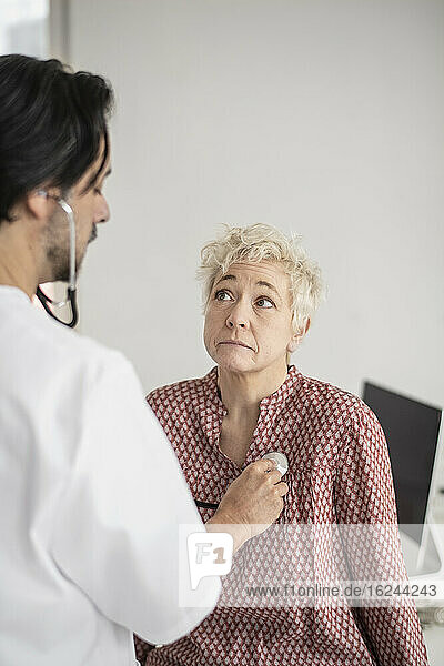 Arzt mit Stethoskop bei der Untersuchung eines Patienten