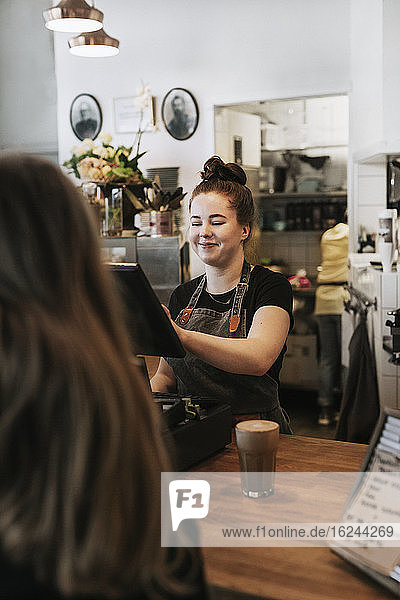 Smiling woman working in cafe