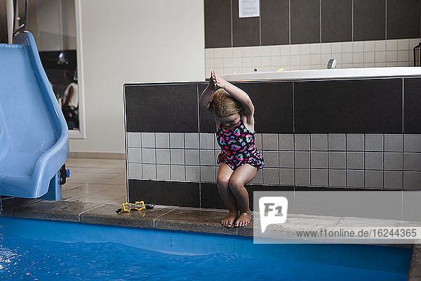 Mädchen springt ins Schwimmbad