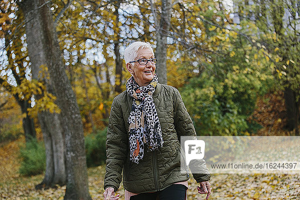 Ältere Frau beim Spaziergang im Herbst