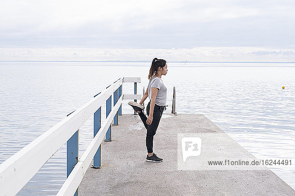 Woman stretching on jetty