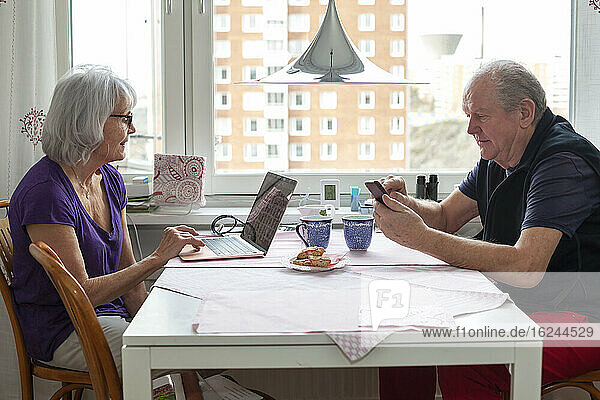 Älteres Paar sitzt am Tisch