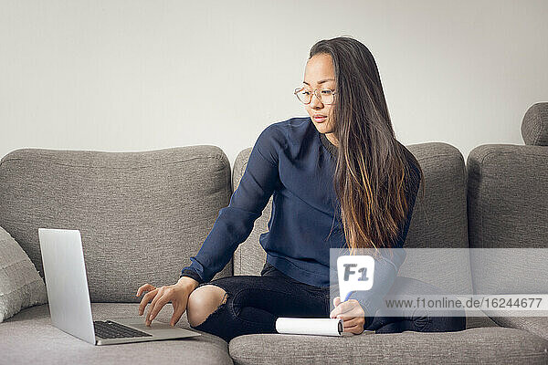 Woman using laptop on sofa