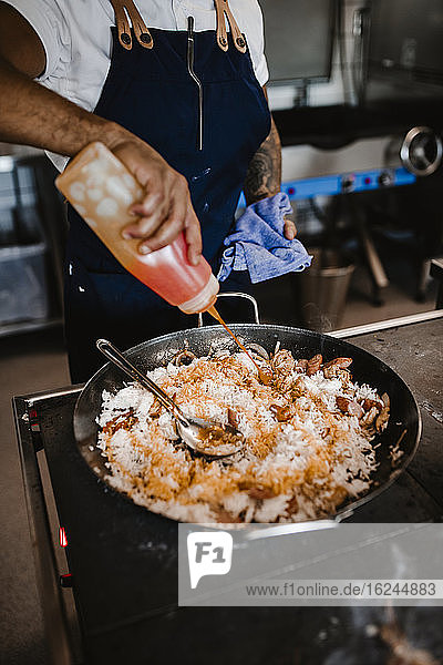 Koch bereitet Paella zu