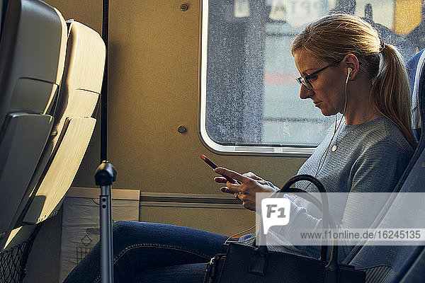 Frau im Zug mit Mobiltelefon