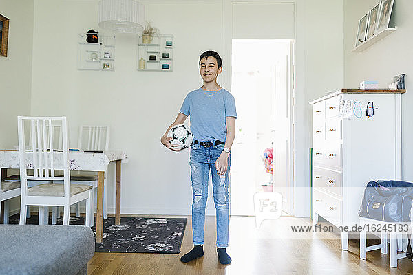 Junge mit Fußball zu Hause